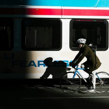 hotos/person-ride-on-city-bike-on-asphalt-road-beside-white-bus-KHrGmSkE6rE