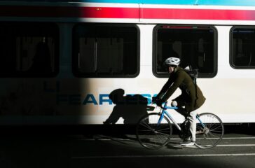 hotos/person-ride-on-city-bike-on-asphalt-road-beside-white-bus-KHrGmSkE6rE