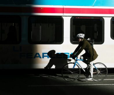 hotos/person-ride-on-city-bike-on-asphalt-road-beside-white-bus-KHrGmSkE6rE