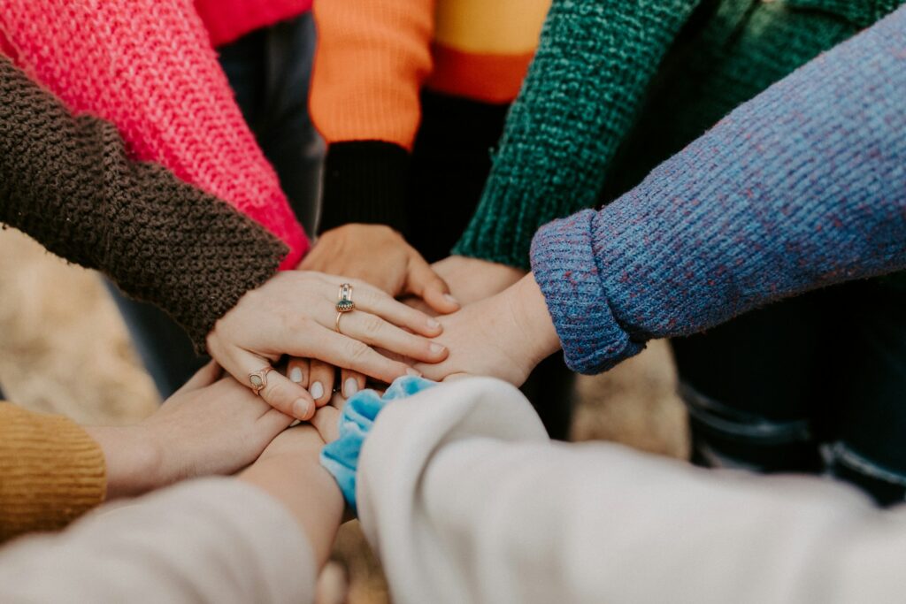 person-in-red-sweater-holding-babys-hand-Zyx1bK9mqmA