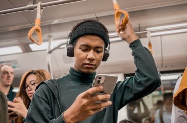 man-in-train-holding-smartphone-oqY09oVTa3k