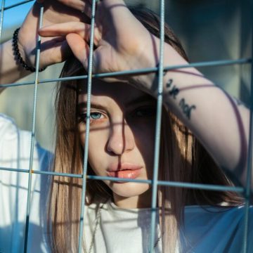 photo-of-woman-leaning-on-screen-fence-2926249/