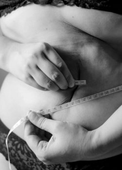 grayscale-photo-of-woman-holding-her-breast-Fu7RNjl-pW0