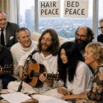 recriação artística de John Lennon, Yoko Ono e convidados a gravarem Give Peace a Chance num quarto de hotel em Montreal em 1969