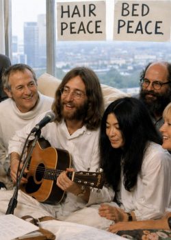 recriação artística de John Lennon, Yoko Ono e convidados a gravarem Give Peace a Chance num quarto de hotel em Montreal em 1969