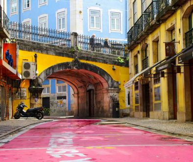 Rua colorida-em-isboa-motocicleta-estacionada-perto-do-edifício-durante-o-dia-CTBrAKr4-4A