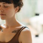 woman-in-sports-bra-with-eyes-closed-7663299/